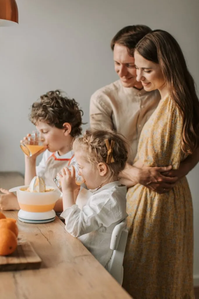 Familie pregătind împreună o masă simplă și economică în bucătăria de acasă